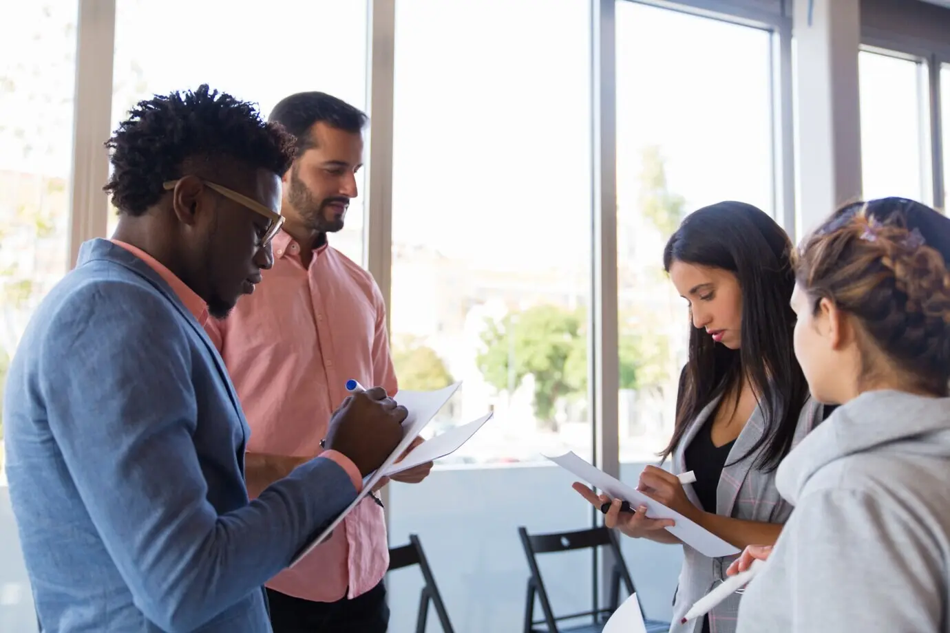 Разнообразные коллеги делают заметки, обмениваясь идеями.