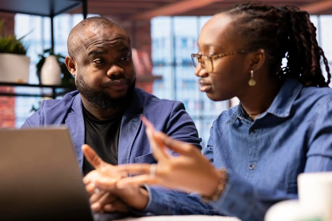 Счастливая пара оформляет бронирования для семейного отпуска на ноутбуке.